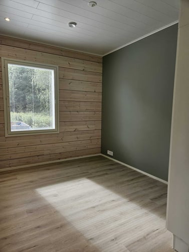 Hirsitalon makuuhuone vihreällä väliseinällä