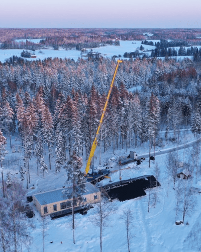 talvinen maisema, jossa rakennetaan omakotitaloa